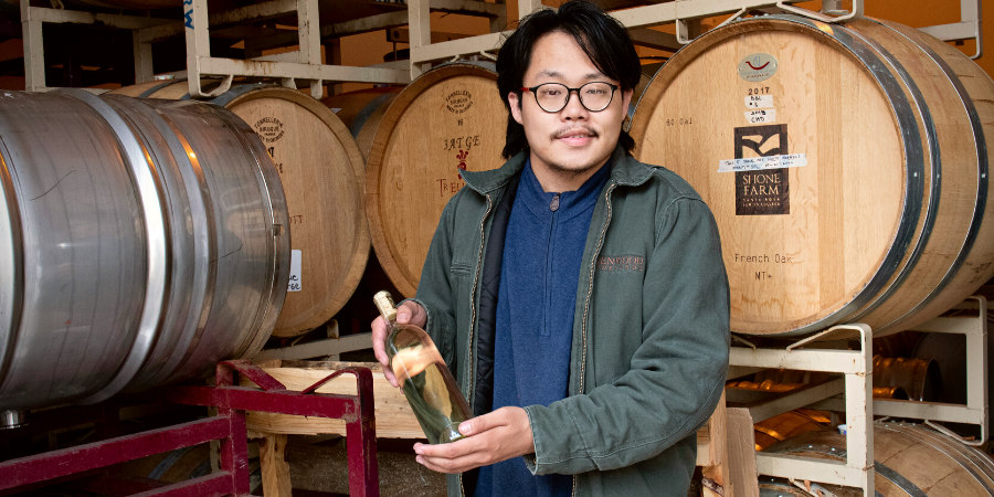 Student presenting a bottle of wine at the Shone Farm winery