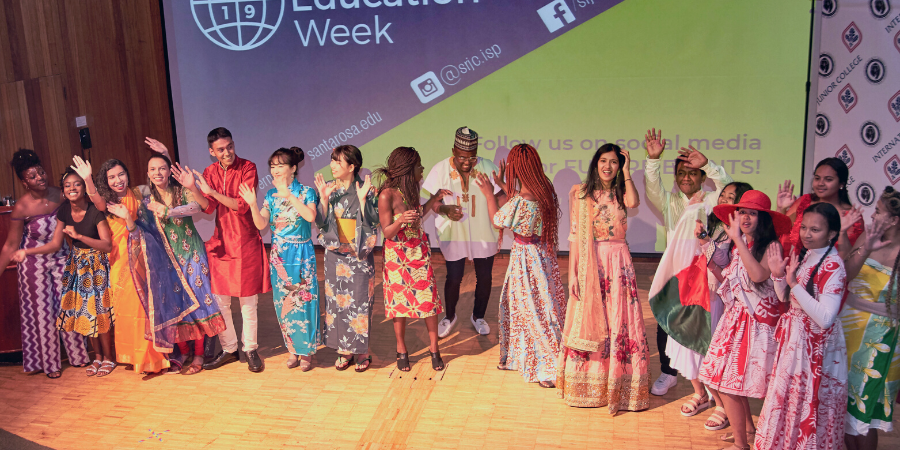 Students modeling traditional clothing at a fashion show. 