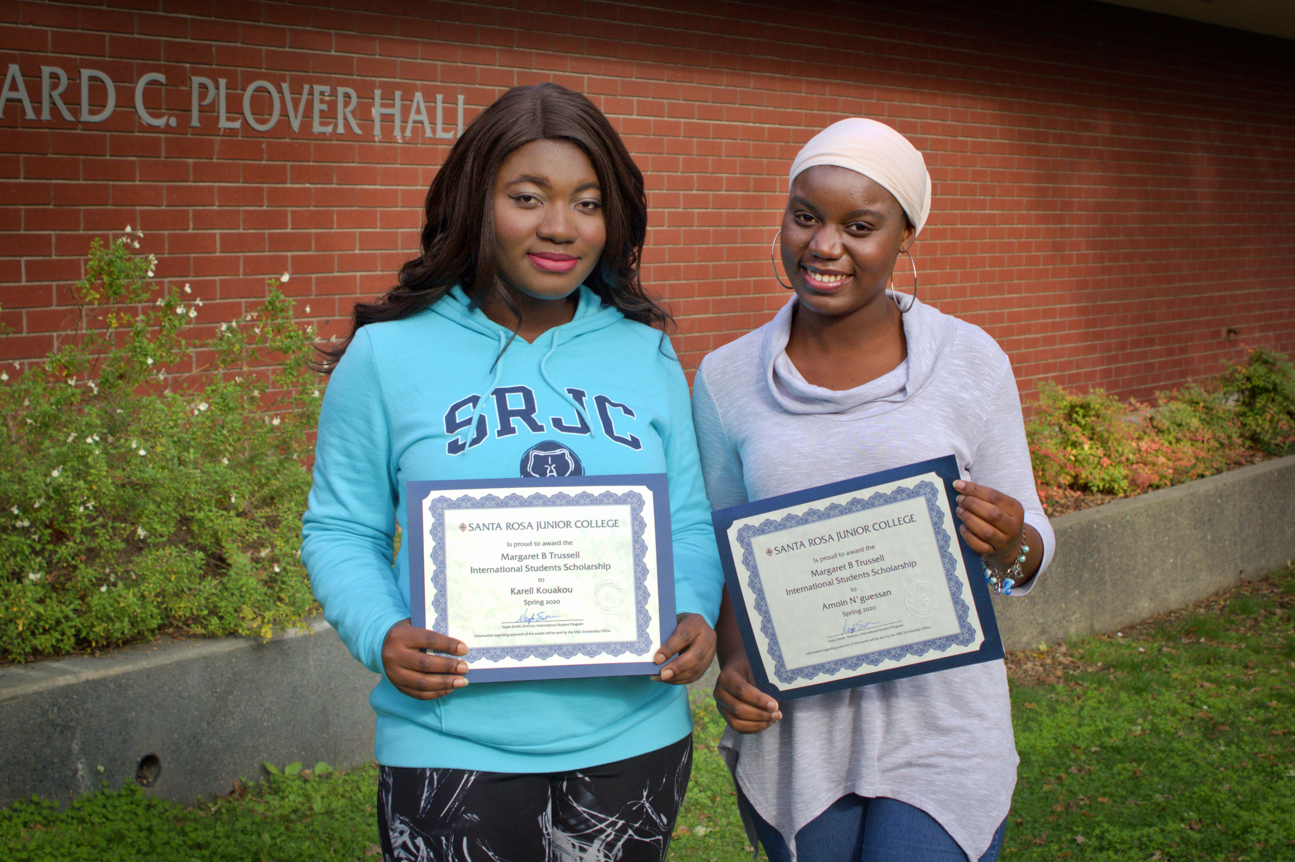 Two students holding certificates