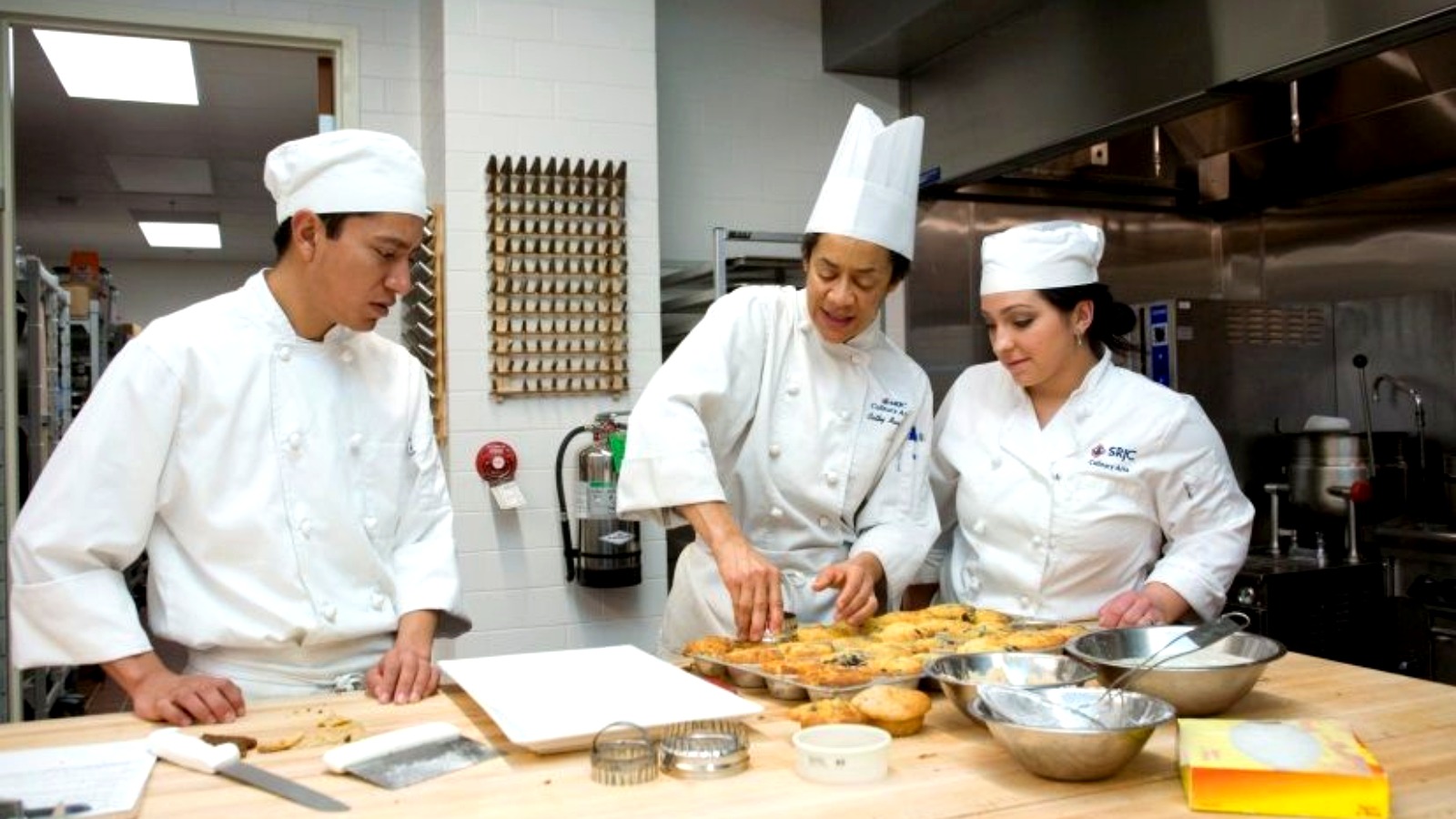 Culinary students preparing dishes in a professional teaching kitchen.