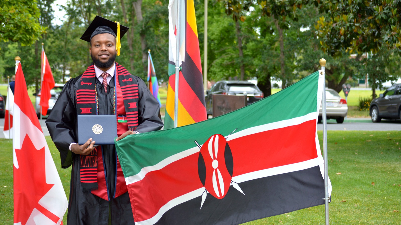 A group of international students wearing graduation regalia and celebrating together.