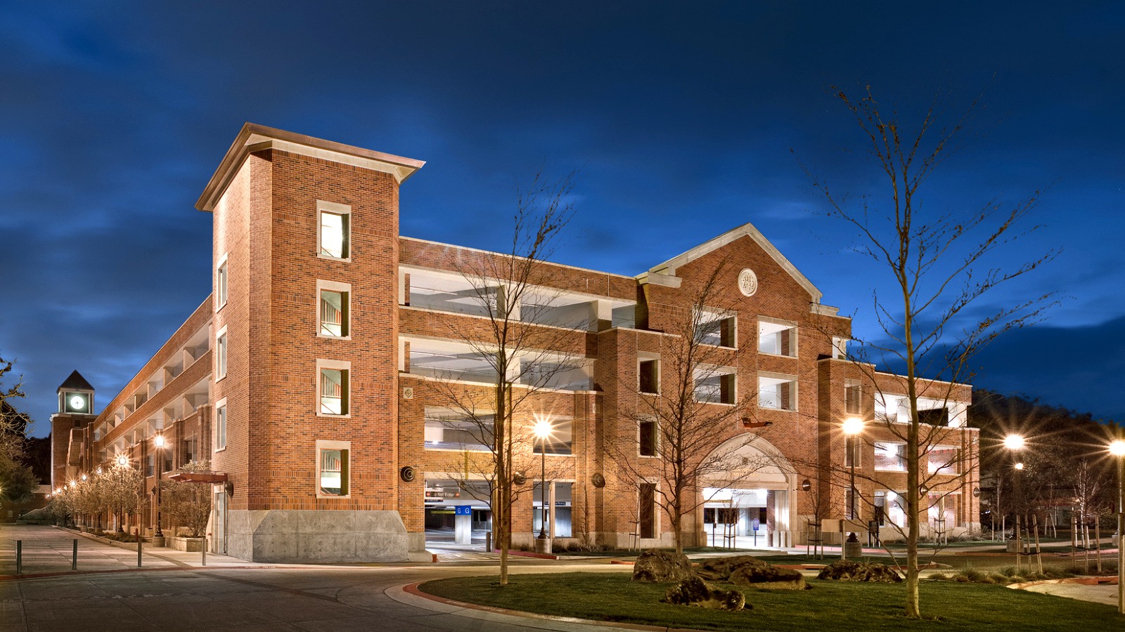 SRJC's multi-level parking structure illuminated at night with the clock tower visible in the background.