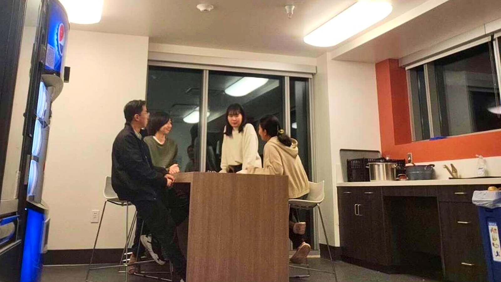Students sitting together in the shared kitchen of the residence hall.
